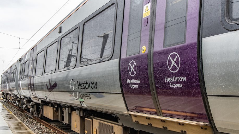 A photo of the outside of the Heathrow Express Train.  The train is purple and grey.